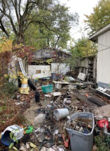 Picture of refuse and unapproved storage on the side of a property