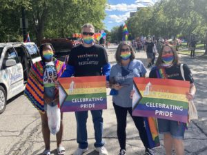 4 people standing holding Champaign Pride signs