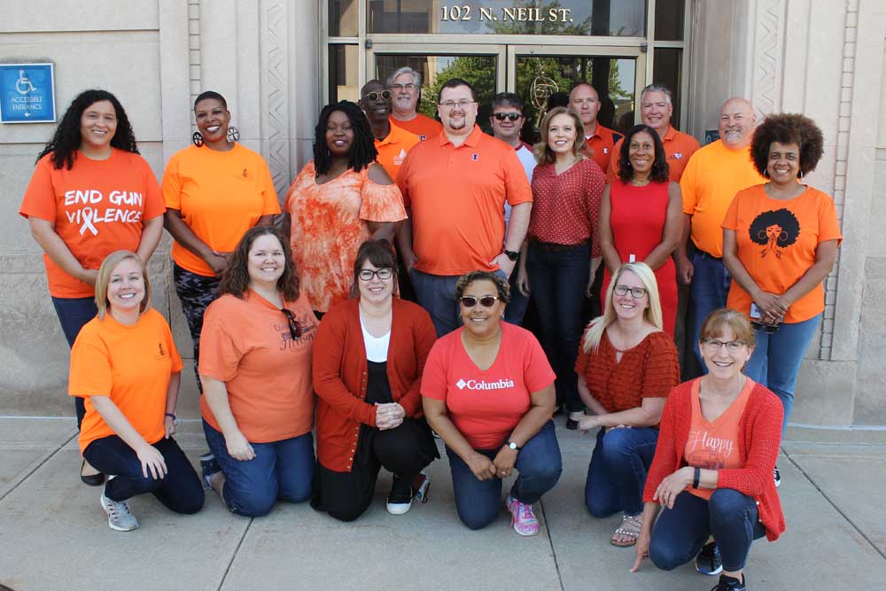 Staff wearing orange clothing outside the City Building