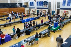 Rows of tables in a gym at a job fair
