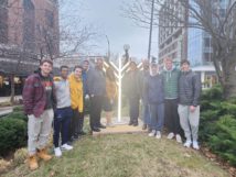 Acting Community Relations Manager Mary Catherine Roberson (Equity and Engagement Department) joins Xander Hazel (Champaign Center Partnership), Rabbi Tiechtel (Illini Chabad), and U of I students for the lighting of the menorah.