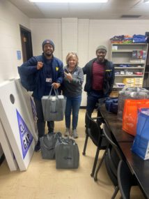 Justice Victim Advocates Jarrel Young and Eric Toga gather hygiene bags with CU Church’s Julie Pioletti.