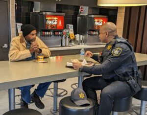 A CPD Officer speaks with a resident at Coffee with a Cop