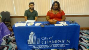 Ricardo Alvarez (left) and Nina Sibley (right) sit at a resource table at a re-entry resource fair. 