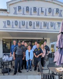 Mayor Feinen poses with members of the Champaign Police Dept and other City Staff at Coffee With a Cop 