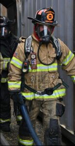 Explorer carrying a tool in firefighting gear